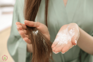 femme qui s'applique un shampoing sec dans les cheveux