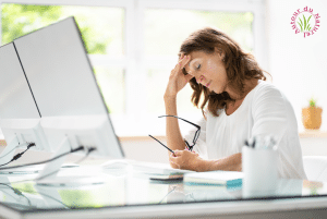 femme fatiguée qui se tient la tête devant son ordinateur