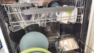 intérieur d'un lave vaisselle ouvert avec le filtre visible au fond de la cuve