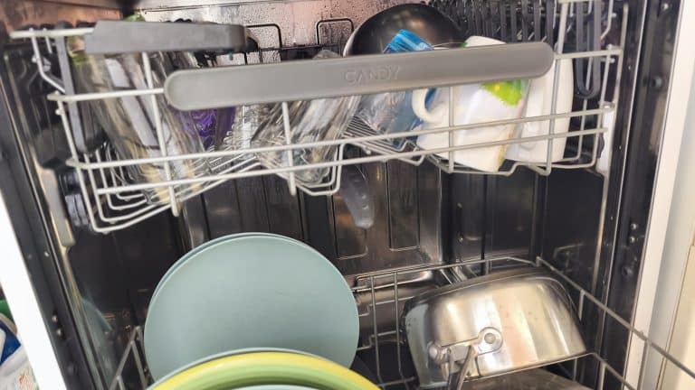 intérieur d'un lave vaisselle ouvert avec le filtre visible au fond de la cuve
